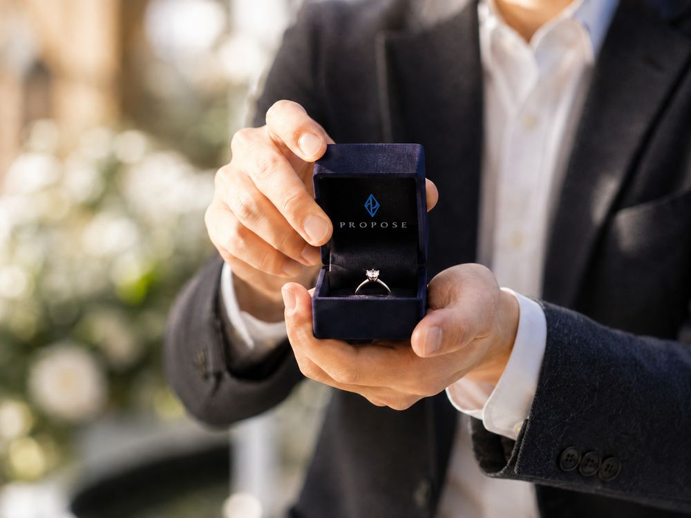 PROPOSEのリングケースを開いて婚約指輪を差し出す男性