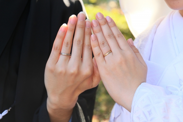 ゴールドの指輪をつけた和装カップルのイメージ写真