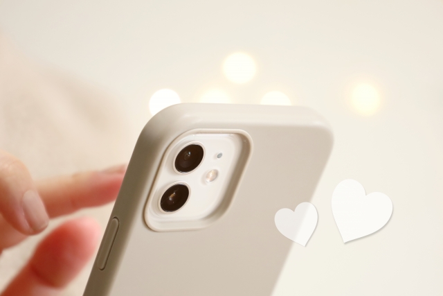 スマホを持つ手とハートのイメージ写真